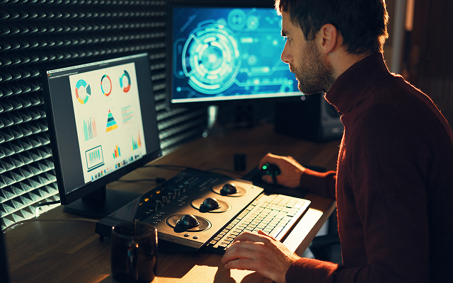 Młody mężczyzna przed komputerem sprawdza jak inwestować na giełdzie.