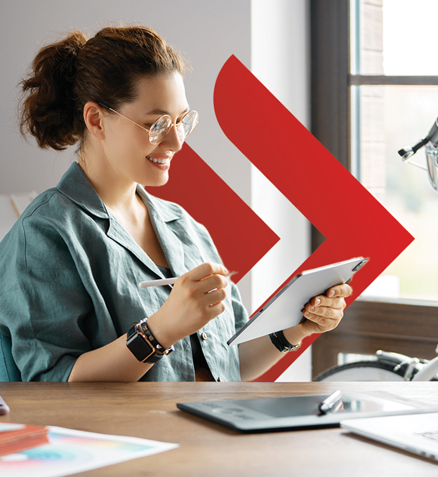Uśmiechnięta kobieta oglądająca ofertę kredytu dla firm UniCredit na tablecie.