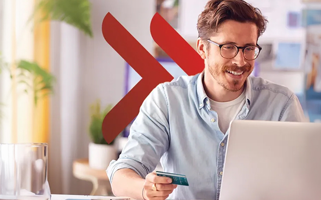 Młody mężczyzna robiący zakupy online przy użyciu karty firmowej UniCredit.